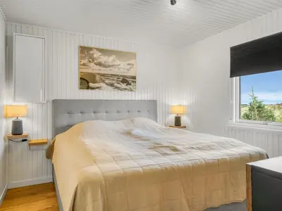 a white bedroom with a bed and a window at Holiday Home Sarika - 500m from the sea by Interhome in Fjerritslev
