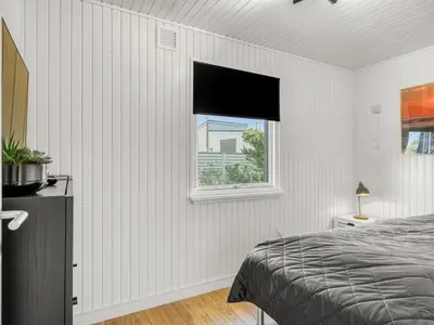 a white bedroom with a bed and a window at Holiday Home Sarika - 500m from the sea by Interhome in Fjerritslev