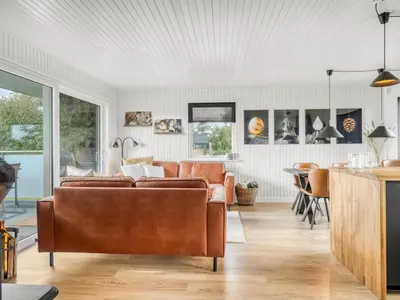 a living room with a couch and a table at Holiday Home Sarika - 500m from the sea by Interhome in Fjerritslev