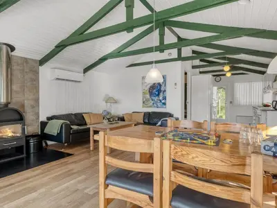 a dining room and living room with a table and a fireplace at Holiday Home Inola - 3-5km from the sea by Interhome in Fjerritslev