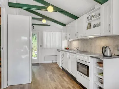 a kitchen with white cabinets and a green ceiling at Holiday Home Inola - 3-5km from the sea by Interhome in Fjerritslev