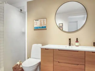 a bathroom with a white toilet and a mirror at Holiday Home Adelbrand - 1km from the sea by Interhome in Blokhus