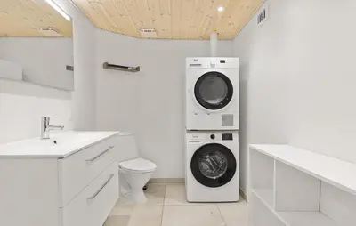 a white bathroom with a washing machine and a washer at Cozy Home In Løgstør With Sauna in Løgstør