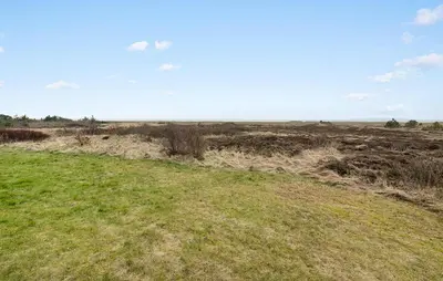 a field with a grassy field with trees in the distance at Cozy Home In Løgstør With Sauna in Løgstør
