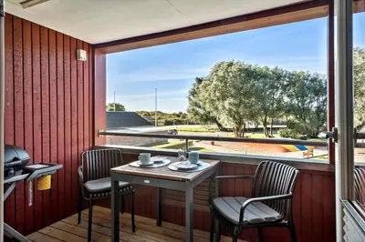 a balcony with a table and chairs and a large window at G346-Lemvig-Vinkelhagevej-46 in Lemvig