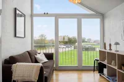 a living room with a couch and large sliding glass doors at G186-Lemvig-Vinkelhagevej-186 in Lemvig