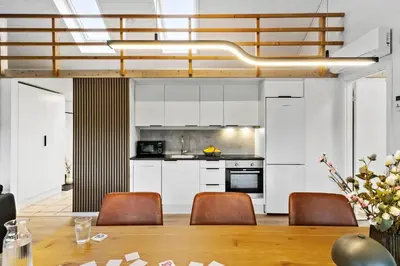 a kitchen with white cabinets and a table and chairs at JB362-Brovst-Kronvildtvej-136 in Brovst