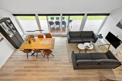 a living room with a dining room table and chairs at JB362-Brovst-Kronvildtvej-136 in Brovst