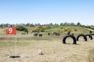 a soccer ball sitting in a field with tires at JB362-Brovst-Kronvildtvej-136 in Brovst