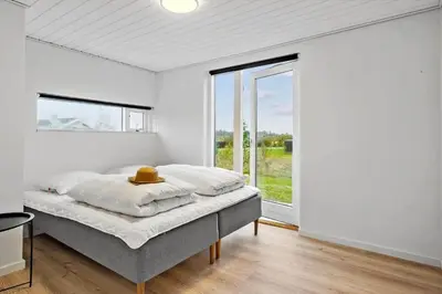 a bedroom with a bed and a large window at JB362-Brovst-Kronvildtvej-136 in Brovst