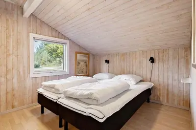 a large bed in a room with a wooden ceiling at BL1129-Saltum-Ornebjergvej-6 in Saltum