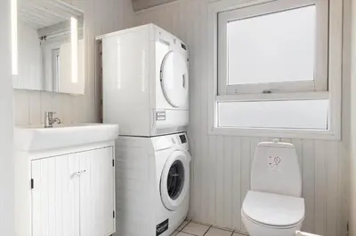 a white bathroom with a washing machine and a sink at BL1129-Saltum-Ornebjergvej-6 in Saltum