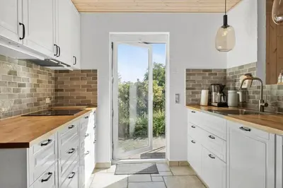 a kitchen with white cabinets and a large window at 852-Bedsted-Thy-Istrupvej-35 in Bedsted Thy