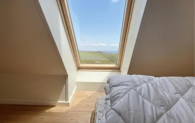 a bed in a room with a large window at 4 Bedroom Beach Front Home In Vinderup in Vinderup