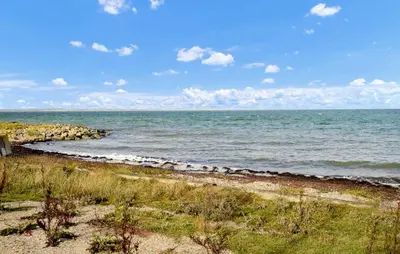 a beach with the ocean on a sunny day at 4 Bedroom Beach Front Home In Vinderup in Vinderup