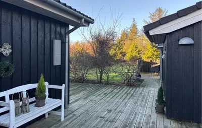 a wooden deck with a bench and a building at Lovely Home In Fjerritslev With Wifi in Fjerritslev