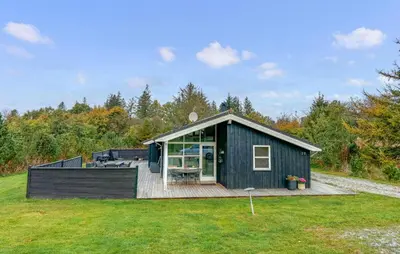 a black cabin with a deck in a field at Lovely Home In Fjerritslev With Wifi in Fjerritslev