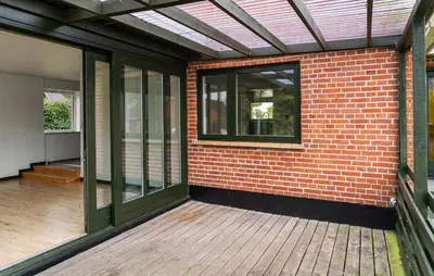 a brick building with a window and a wooden deck at 1 Bedroom Nice Home In Hurup Thy in Ullerup