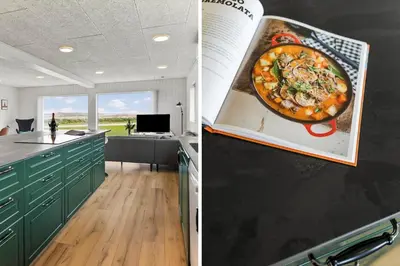 a kitchen with green cabinets and a painting of a pizza at 820-Harboore-Bjergehusvej-19 in Harboør