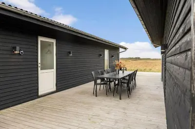 a patio with a table and chairs on a deck at 820-Harboore-Bjergehusvej-19 in Harboør
