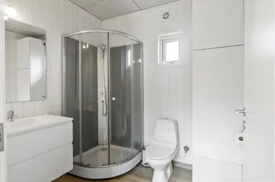 a bathroom with a shower and a toilet and a sink at 820-Harboore-Bjergehusvej-19 in Harboør