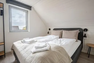 a bedroom with a bed with towels on it at City Apartments in Holstebro