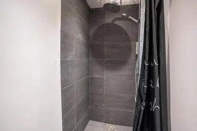 a shower with a black shower curtain in a bathroom at City Apartments in Holstebro
