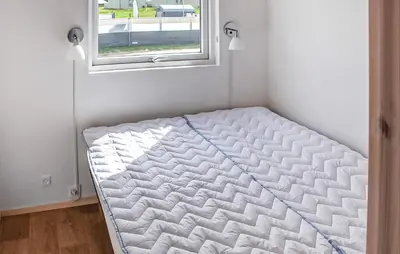 a bed sitting in a room next to a window at Gorgeous Home In Hanstholm With House Sea View in Hanstholm