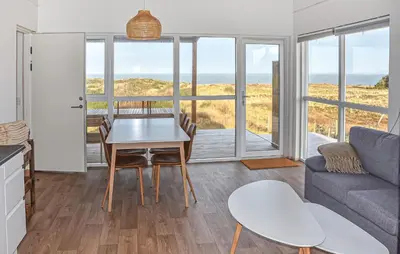 a living room with a table and a couch at Gorgeous Home In Hanstholm With House Sea View in Hanstholm