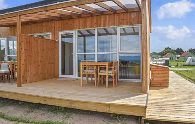 a wooden cabin with a table and chairs on a deck at Nice Home In Hanstholm With House Sea View in Hanstholm