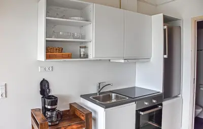 a kitchen with white cabinets and a sink at Nice Home In Hanstholm With House Sea View in Hanstholm