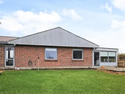 a brick house with a large lawn in front of it at 6 person holiday home in Lemvig in Lemvig
