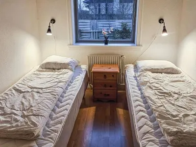 two beds in a room with a table and a window at 6 person holiday home in Lemvig in Lemvig