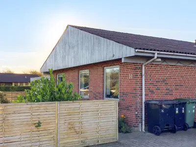 a brick house with a wooden fence in front of it at 6 person holiday home in Lemvig in Lemvig
