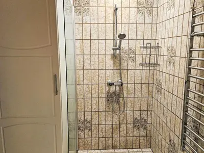 a shower in a bathroom with a tiled wall at 6 person holiday home in Lemvig in Lemvig