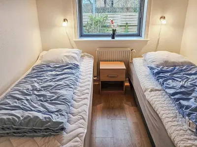 two beds in a room with a table and a window at 6 person holiday home in Lemvig in Lemvig