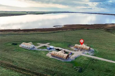 an aerial view of a building in a field near a body of water at 819-Harboore-Neerlandiavej-87 in Harboør