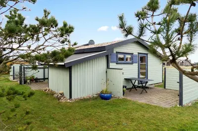 a small white shed with a picnic table in a yard at 1069-Thisted-Kobbelsti-23 in Thisted