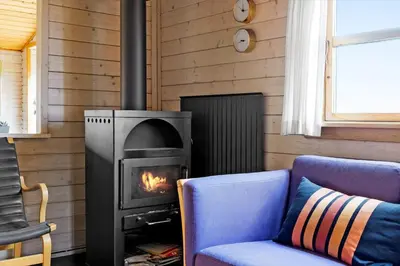 a fireplace in a room with a couch and a stove at 1069-Thisted-Kobbelsti-23 in Thisted