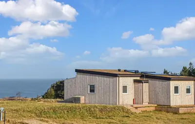 a house on a hill with the ocean in the background at 5 Bedroom Amazing Home In Hanstholm in Hanstholm