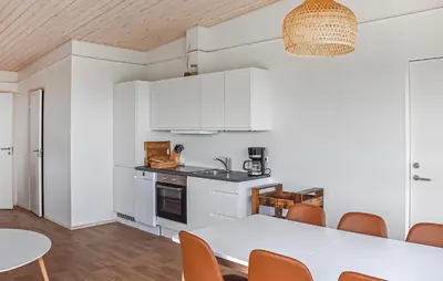 a kitchen and dining room with a table and chairs at 5 Bedroom Amazing Home In Hanstholm in Hanstholm