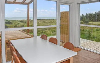 a kitchen with a white table and chairs and windows at 5 Bedroom Amazing Home In Hanstholm in Hanstholm