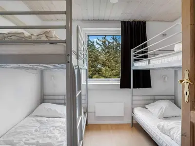 two bunk beds in a room with a window at 4 star holiday home in Harboøre in Harboør