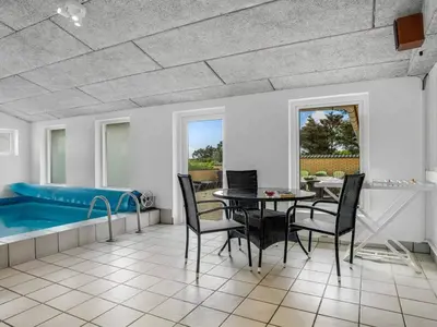 a dining room with a table and a tub at 4 star holiday home in Harboøre in Harboør
