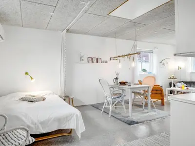 a bedroom with a bed and a table and chairs at Holiday Home Sylvana - 75m from the sea by Interhome in Thisted