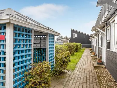a building with blue windows next to a brick sidewalk at Apartment Benthe - 100m to the fjord by Interhome in Vestervig