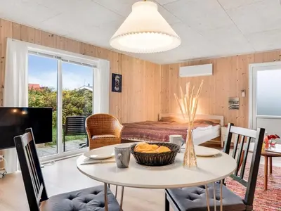 a living room with a table and a bed at Holiday Home Tekla - 75m from the sea by Interhome in Thisted