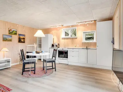 a kitchen with a table and chairs in a room at Holiday Home Tekla - 75m from the sea by Interhome in Thisted