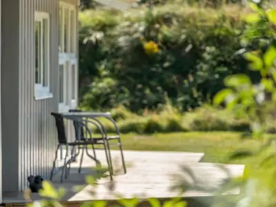 a pair of chairs sitting on the porch of a house at Holiday Home Melita - 2km from the sea by Interhome in Blokhus