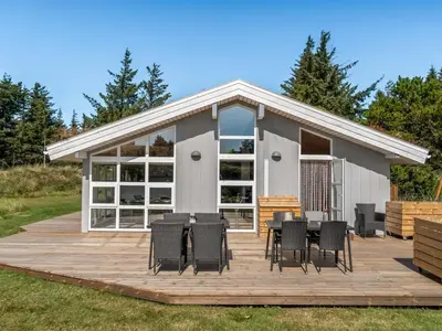 a large deck with chairs and tables on it at Holiday Home Melita - 2km from the sea by Interhome in Blokhus